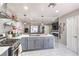 Open kitchen showcasing stainless steel appliances, gas range and stylish tile flooring that leads to the living area at 5453 Palisades Quad Ave, Las Vegas, NV 89122