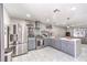 Bright kitchen with gray cabinetry, stainless steel appliances, quartz countertops and open floorplan to living room at 5453 Palisades Quad Ave, Las Vegas, NV 89122
