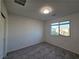 Neutrally decorated bedroom with carpet flooring and a view of the neighborhood at 5817 Bonita Rose St, Las Vegas, NV 89113