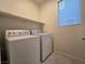 Functional laundry room with a washer, dryer, and storage shelf, offering convenience and organization at 5817 Bonita Rose St, Las Vegas, NV 89113
