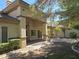 Covered patio with decorative stone pillars, brick flooring, ceiling fans, and lush landscaping at 601 Summer Mesa Dr, Las Vegas, NV 89144