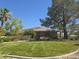 Well maintained home with lush green lawn and mature trees in the front yard at 601 Summer Mesa Dr, Las Vegas, NV 89144