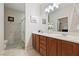Bathroom featuring double sinks, wood cabinets, a walk-in shower, and neutral color scheme at 6114 Saddle Horse Ave, Las Vegas, NV 89122