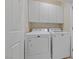Well-equipped laundry room with white cabinets and washer/dryer units at 6114 Saddle Horse Ave, Las Vegas, NV 89122