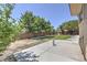 Private backyard featuring lush lawn, mature trees, desert landscaping, and a concrete patio at 6821 Sleepy Pine St, Las Vegas, NV 89130