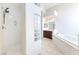 Clean bathroom with glass block accents, tiled floors, walk-in shower, and soaking tub at 6821 Sleepy Pine St, Las Vegas, NV 89130