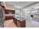 Open kitchen featuring dark wood cabinets, an island with a sink, and views into the living room at 6821 Sleepy Pine St, Las Vegas, NV 89130