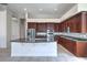 Spacious kitchen featuring a central island with a sink, stainless steel appliances, and tile flooring at 6821 Sleepy Pine St, Las Vegas, NV 89130