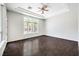 Bright living room with wood floors, a ceiling fan, and large windows overlooking the backyard at 6821 Sleepy Pine St, Las Vegas, NV 89130