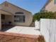 View of the backyard showing the covered patio, the house, and a side yard area with a white fence at 7542 Mycroft Ct, Las Vegas, NV 89147