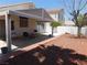 Spacious covered patio and a backyard with minimal landscaping and a white fence at 7542 Mycroft Ct, Las Vegas, NV 89147