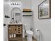 Modern bathroom with wood vanity, black fixtures, floating shelves, and wood-look flooring at 7706 Crystal Village Ln, Las Vegas, NV 89113