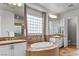 Bright bathroom with a corner tub, tiled counters, and and sinks at 8209 Chapelle Ct, Las Vegas, NV 89131