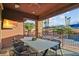 Inviting covered patio with outdoor dining area and views of the sparkling pool and lush landscaping at 8209 Chapelle Ct, Las Vegas, NV 89131