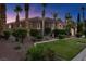 Beautiful home with desert landscaping, green lawn, mature palm trees and a tiled roof at 8209 Chapelle Ct, Las Vegas, NV 89131