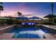 Private pool with built-in spa, umbrellas, and desert landscaping, perfect for outdoor relaxation at 8209 Chapelle Ct, Las Vegas, NV 89131