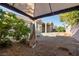 View of the landscaped backyard with desert landscaping and a covered patio from under an awning at 8537 Highland View Ave, Las Vegas, NV 89145