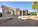 An angle view of the rear exterior showcasing the covered patio and desert landscaping at 8537 Highland View Ave, Las Vegas, NV 89145