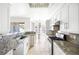 Bright white kitchen with stainless appliances, stone counters and eat in dining area at 8537 Highland View Ave, Las Vegas, NV 89145