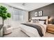 Well-lit bedroom featuring a comfortable bed, accent wall, and a large window for natural light at 9357 Aria Ridge Ave, Las Vegas, NV 89143