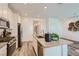 Modern kitchen boasts stainless appliances, an island with bar seating, and bright white cabinets at 9357 Aria Ridge Ave, Las Vegas, NV 89143