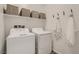 Convenient laundry room with modern washer and dryer, plus shelving at 9357 Aria Ridge Ave, Las Vegas, NV 89143