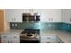 Close up of stainless steel range with white cabinets and teal backsplash at , Las Vegas, NV 89130