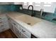 Kitchen with beige sink, white cabinets, black hardware and teal backsplash at , Las Vegas, NV 89130