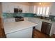 Bright kitchen featuring white cabinets, stainless steel appliances, kitchen island and teal backsplash at , Las Vegas, NV 89130