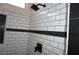 Modern shower featuring white subway tile with a black accent stripe and sleek black fixtures at , Las Vegas, NV 89130