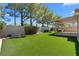 Landscaped backyard featuring artificial grass, brick wall, and covered patio offers a private outdoor space at 1132 Coral Desert Dr, Las Vegas, NV 89123