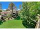 Lush backyard features manicured lawn, mature trees, play area and landscaped garden beds at 1266 Imperia Dr, Henderson, NV 89052