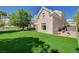 An expansive backyard featuring artificial turf, a covered patio, and mature trees at 1266 Imperia Dr, Henderson, NV 89052