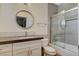 Modern bathroom featuring a glass-enclosed shower, stylish vanity, and round mirror at 1266 Imperia Dr, Henderson, NV 89052