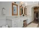 Bathroom with double vanity sinks, decorative mirrors, and a walk-in closet at 1266 Imperia Dr, Henderson, NV 89052