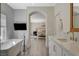 This bathroom features a soaking tub, stone countertops and a bedroom in the background at 1266 Imperia Dr, Henderson, NV 89052