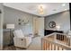 Calm Bedroom features a comfortable armchair, modern crib, and dark dresser at 1266 Imperia Dr, Henderson, NV 89052
