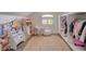 Custom closet with racks and cabinets, filled with books, dolls, and clothes at 1266 Imperia Dr, Henderson, NV 89052