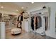 Bright walk-in closet featuring custom shelving, drawers, and an ottoman at 1266 Imperia Dr, Henderson, NV 89052