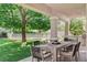 Inviting covered patio featuring an outdoor dining set, swing, built-in grill and backyard views at 1266 Imperia Dr, Henderson, NV 89052