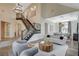 Bright living room showcasing a staircase, elegant chandelier, and contemporary decor at 1266 Imperia Dr, Henderson, NV 89052