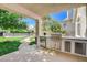 Outdoor kitchen on the covered patio boasts stainless steel grill, lush backyard, and pool in background at 1266 Imperia Dr, Henderson, NV 89052