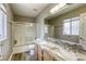 Bathroom features a double sink vanity with marble countertop and shower with sliding glass doors at 1320 Rainbow Meadows Dr, Las Vegas, NV 89128