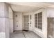 Close-up of covered front porch with security door, window, textured walls and concrete flooring at 1320 Rainbow Meadows Dr, Las Vegas, NV 89128