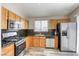 Well-lit kitchen features stainless steel appliances and wooden cabinets and hard surface counter tops at 1320 Rainbow Meadows Dr, Las Vegas, NV 89128