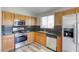 Cozy kitchen featuring stainless steel appliances, ample wood cabinetry and granite countertops at 1320 Rainbow Meadows Dr, Las Vegas, NV 89128