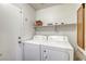 Functional laundry room with a washer and dryer, shelf for storing supplies at 1320 Rainbow Meadows Dr, Las Vegas, NV 89128