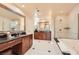 Well-lit bathroom featuring a bathtub, walk-in shower, and spacious double vanity at 145 E Harmon Ave # 1001, Las Vegas, NV 89109