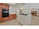 Open kitchen featuring a cooking island, tile floors, oven appliances, and seamless flow into the living area at 1517 Kirby Dr, Las Vegas, NV 89117
