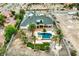 Aerial image of a large home featuring a spacious backyard with a refreshing pool, a putting green, and desert landscaping at 156 N Parawan St, Henderson, NV 89015